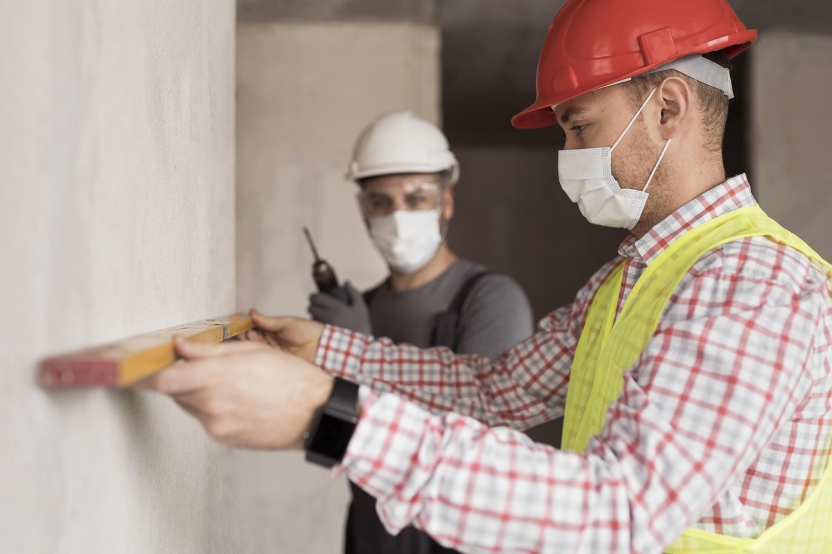 Trabajadores de la construcción usando equipo de protección en un proyecto de edificación.